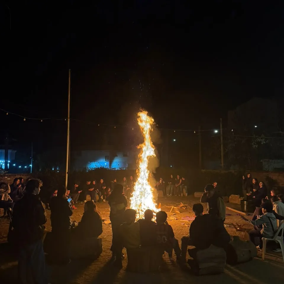 El fogón de La Juntada: los jóvenes en ronda alrededor del fuego, de noche