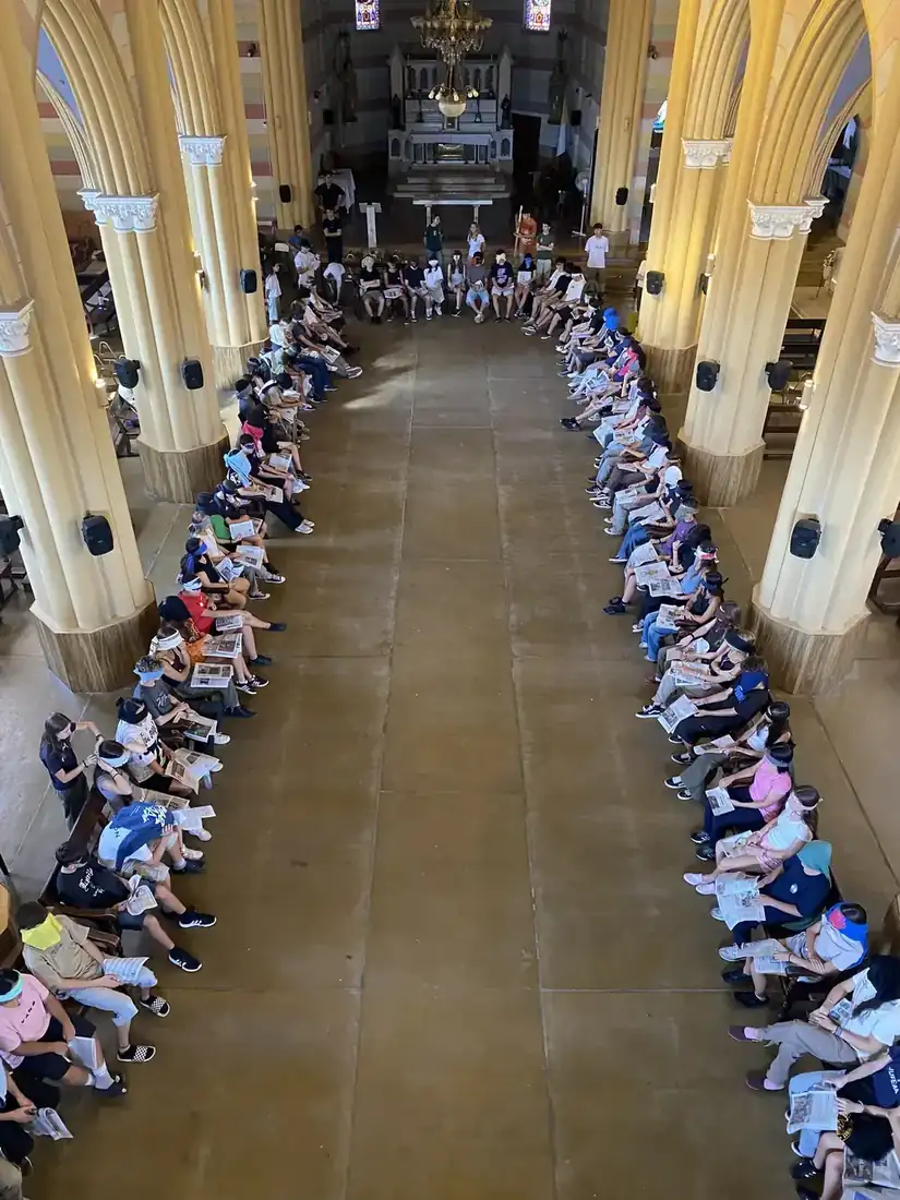 Los jóvenes sentados a lo largo de la nave del templo