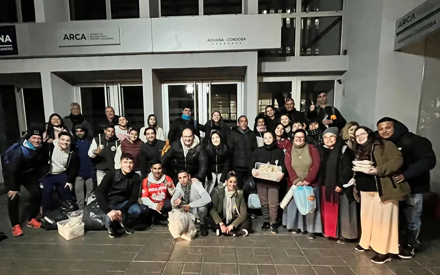 La comunidad reunida de noche antes de salir a repartir las frazadas tejidas por las calles de Córdoba
