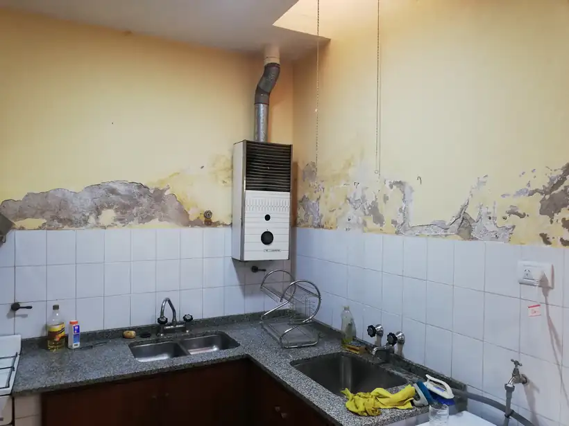 La cocina de la casa parroquial: la humedad había levantado la pared sobre los azulejos