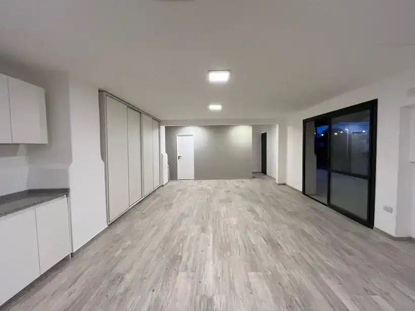 El salón terminado: piso nuevo, paredes blancas y luces embutidas