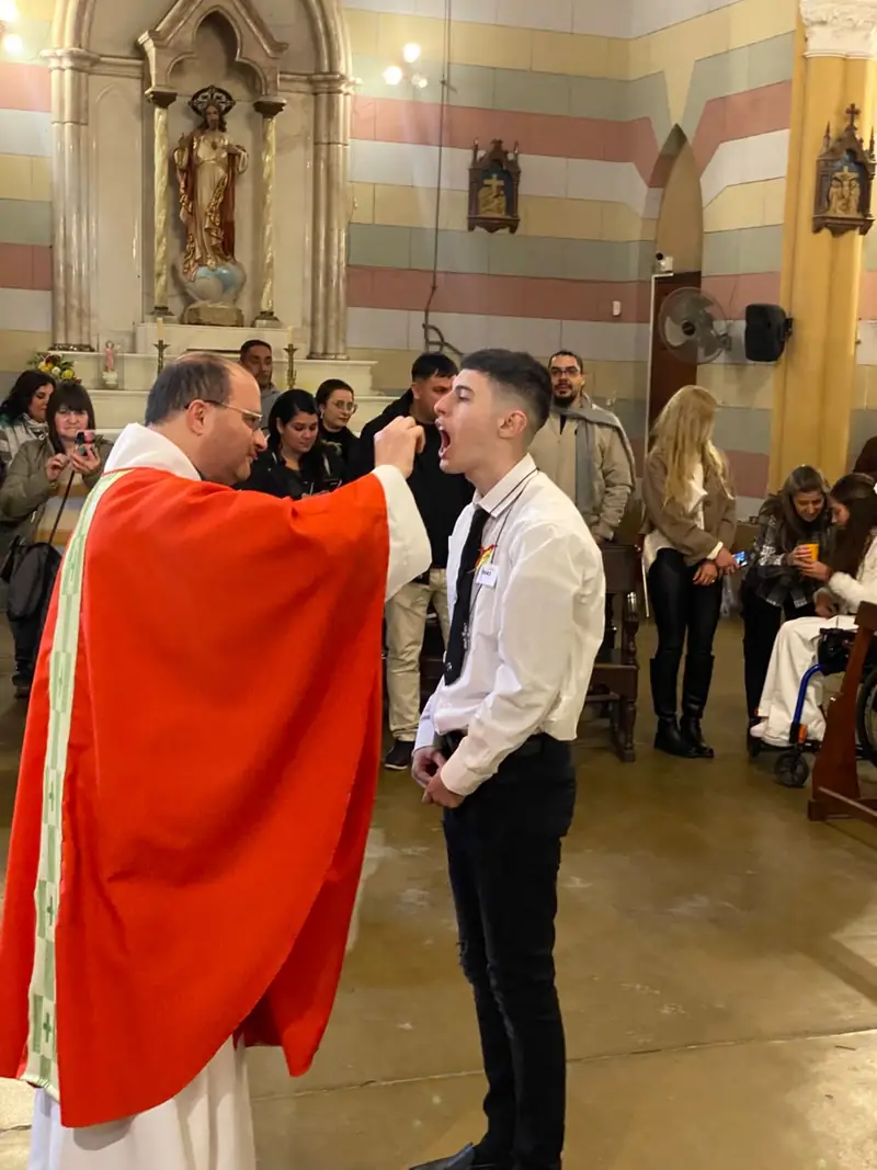 Un joven recibe la comunión frente al altar