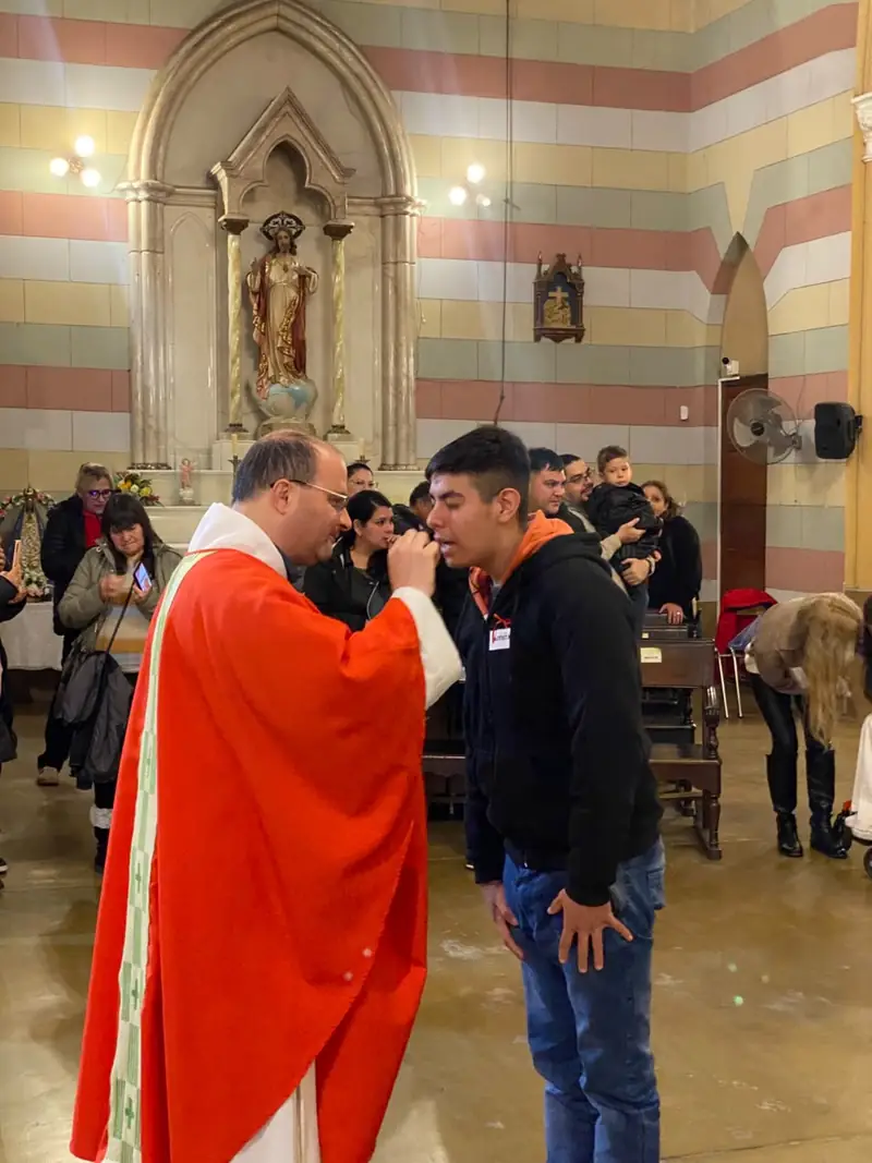 Un joven recibe la comunión en la celebración de sacramentos